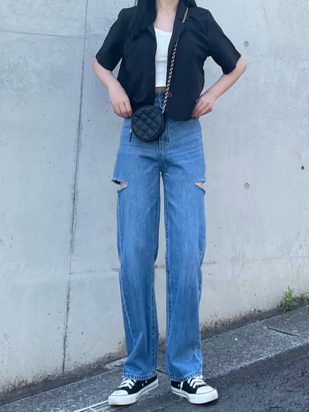 ブラック系のテーラードジャケット、ホワイト系のタンクトップ、ブラック系のショルダーバッグを着用したレディースの夏コーディネートの3枚目の写真