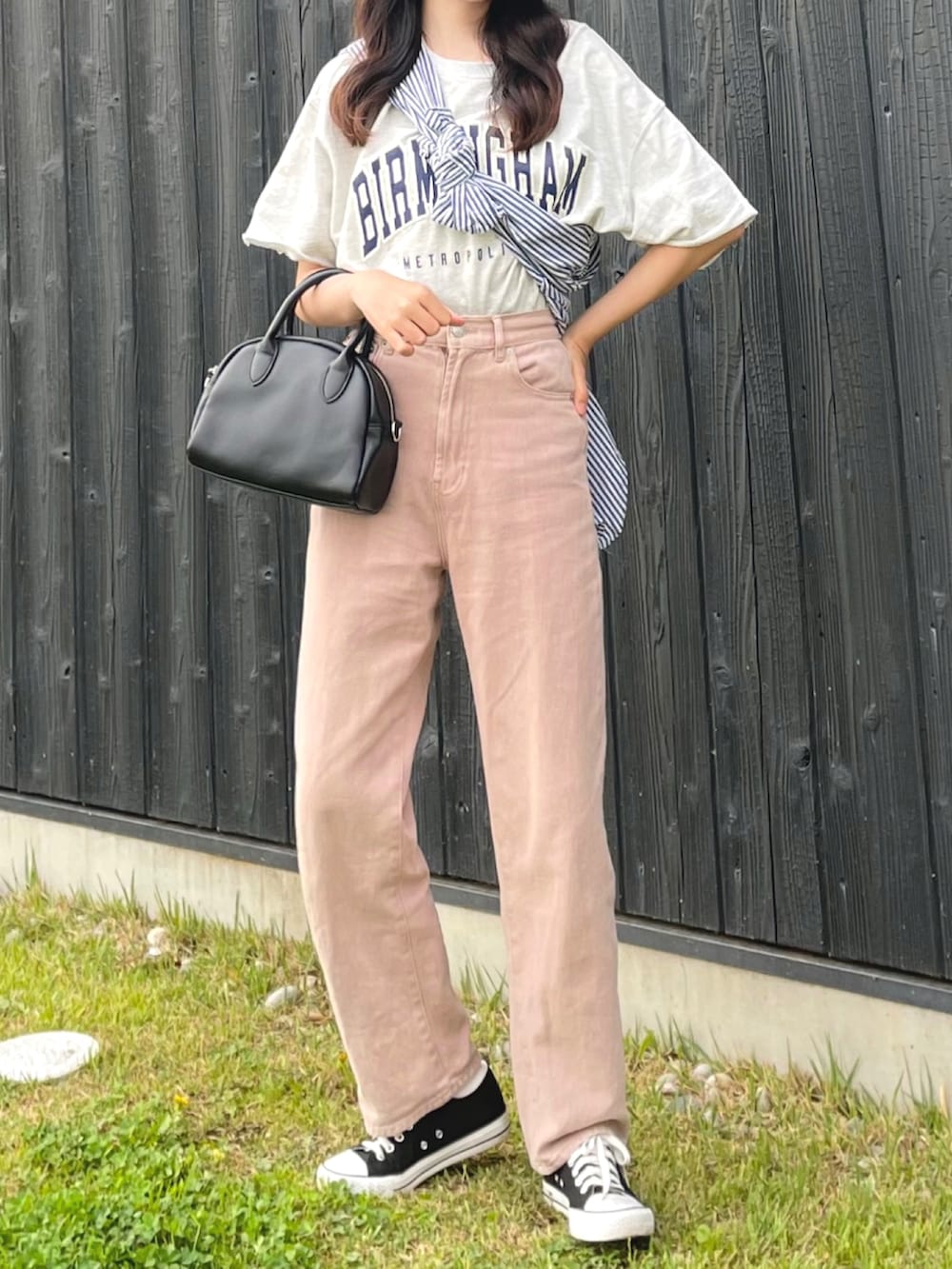 ブラック系のボストンバッグ、ピンク系のデニムパンツ、グレー系のTシャツ/カットソーを着用したレディースの春コーディネートの3枚目の写真