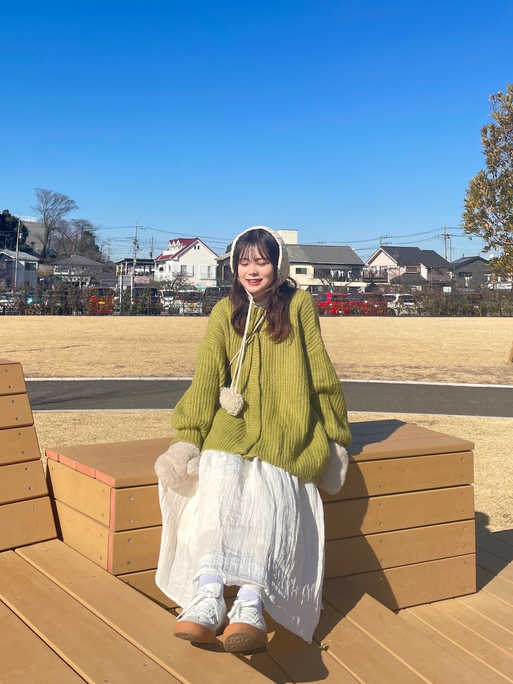 ホワイト系のスニーカー、ホワイト系のスカート、ブラウン系のショルダーバッグを着用したレディースの冬コーディネートの4枚目の写真