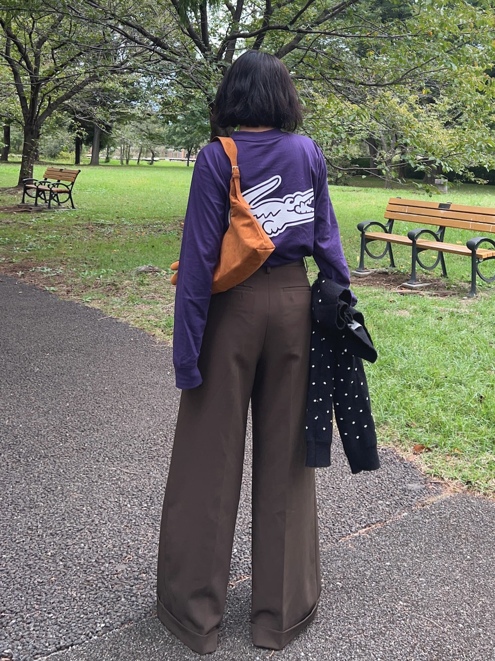 イエロー系のトートバッグ、パープル系のTシャツ/カットソー、ブラック系のカーディガン/ボレロを着用したレディースの秋コーディネートの3枚目の写真