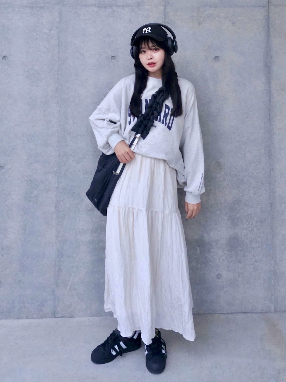 ホワイト系のスウェット、ホワイト系のスカート、ブラック系のスニーカーを着用したレディースの秋コーディネートの2枚目の写真