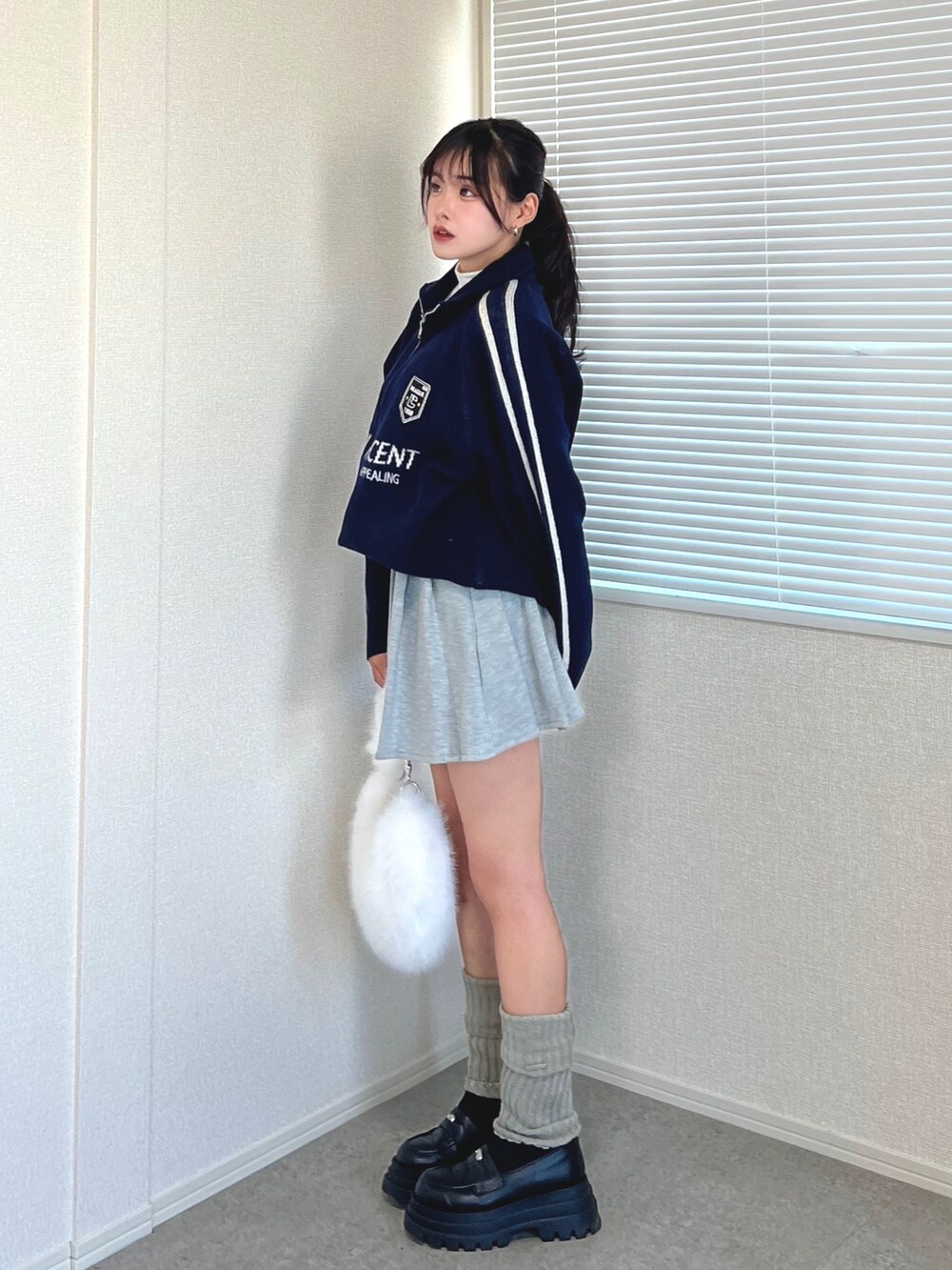 ブルー系のカーディガン/ボレロ、ホワイト系のTシャツ/カットソー、グレー系のスカートを着用したレディースの冬コーディネートの2枚目の写真