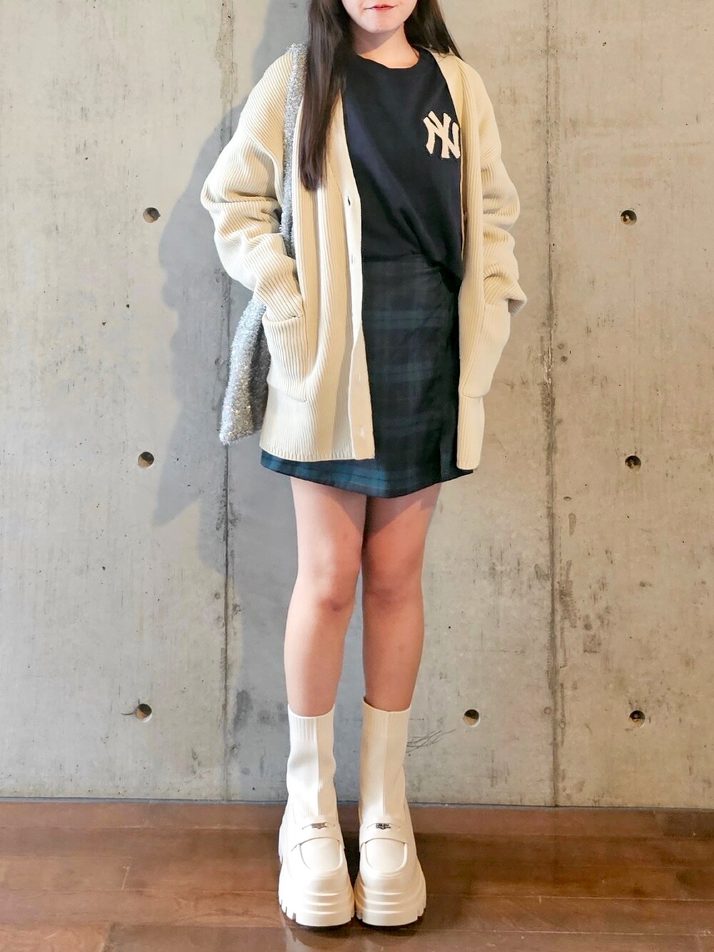 ホワイト系のカーディガン/ボレロ、グリーン系のスカート、シルバー系のショルダーバッグを着用したレディースの秋コーディネートの5枚目の写真