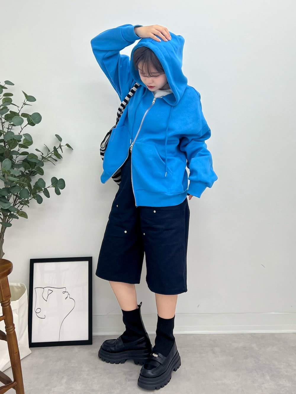 ブルー系のパーカー、ブルー系のチノパンツ、ホワイト系のTシャツ/カットソーを着用したレディースの秋コーディネートの2枚目の写真