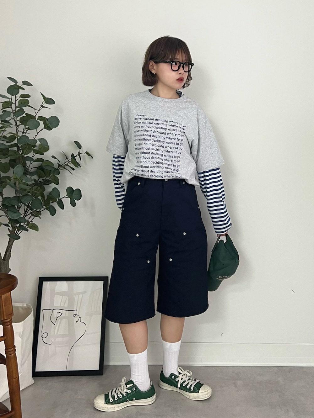 グレー系のTシャツ/カットソー、ブルー系のチノパンツ、グリーン系のスニーカーを着用したレディースの秋コーディネートの2枚目の写真