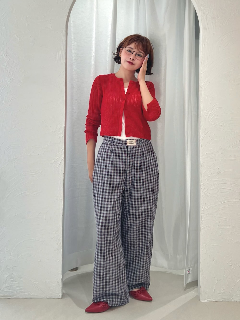 ホワイト系のキャミソール、レッド系のパンプス、ブルー系のスラックスを着用したレディースの秋コーディネートの2枚目の写真