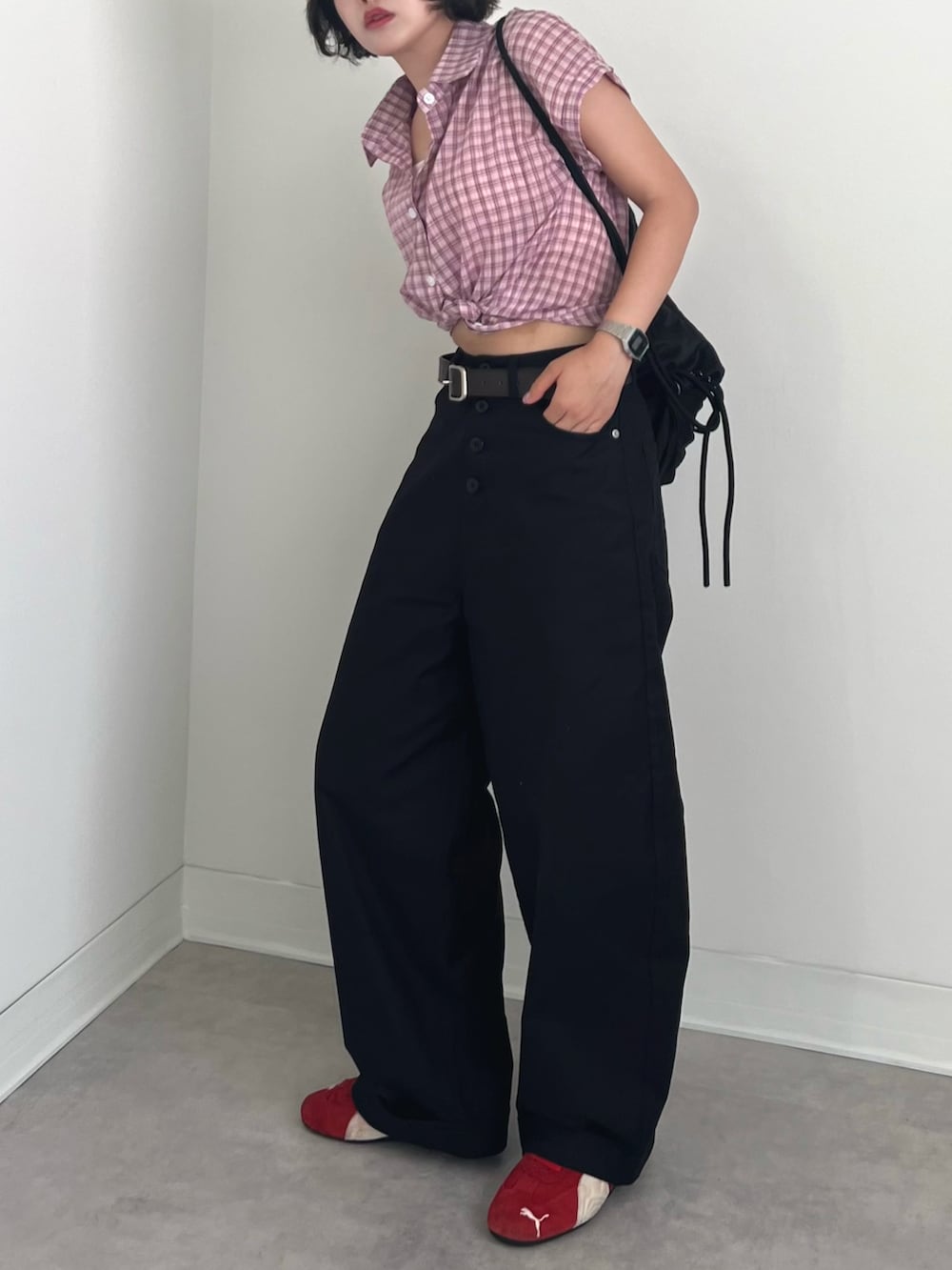 ブラック系のチノパンツ、ピンク系のシャツ/ブラウス、レッド系のスニーカーを着用したレディースの夏コーディネートの3枚目の写真