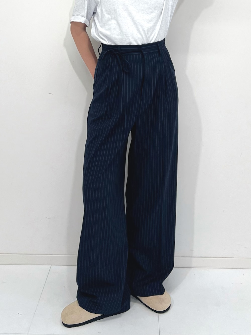 ブルー系のスラックス、ベージュ系のサンダル、ホワイト系のTシャツ/カットソーを着用したレディースの夏コーディネートの3枚目の写真