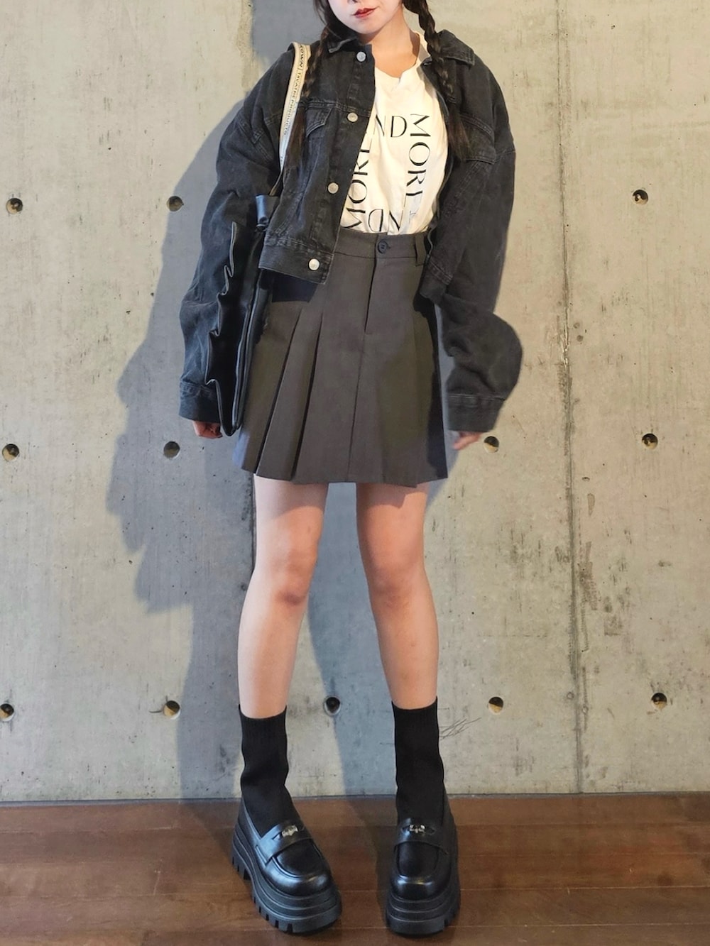 ブラック系のブーツ、ブラック系のデニムジャケット、ホワイト系のTシャツ/カットソーを着用したレディースの秋コーディネートの3枚目の写真