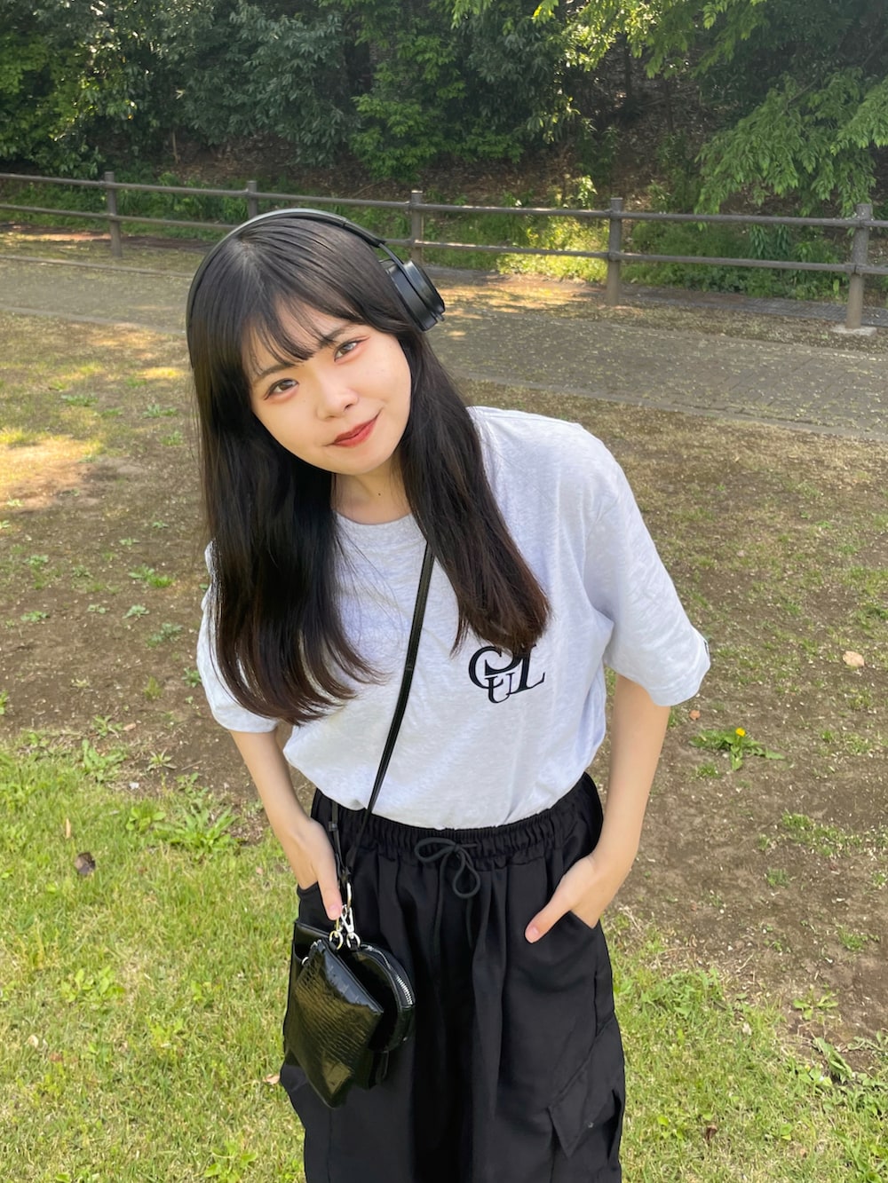 ブラック系のカーゴパンツ、ブラック系のショルダーバッグ、ホワイト系のTシャツ/カットソーを着用したレディースの春コーディネートの2枚目の写真