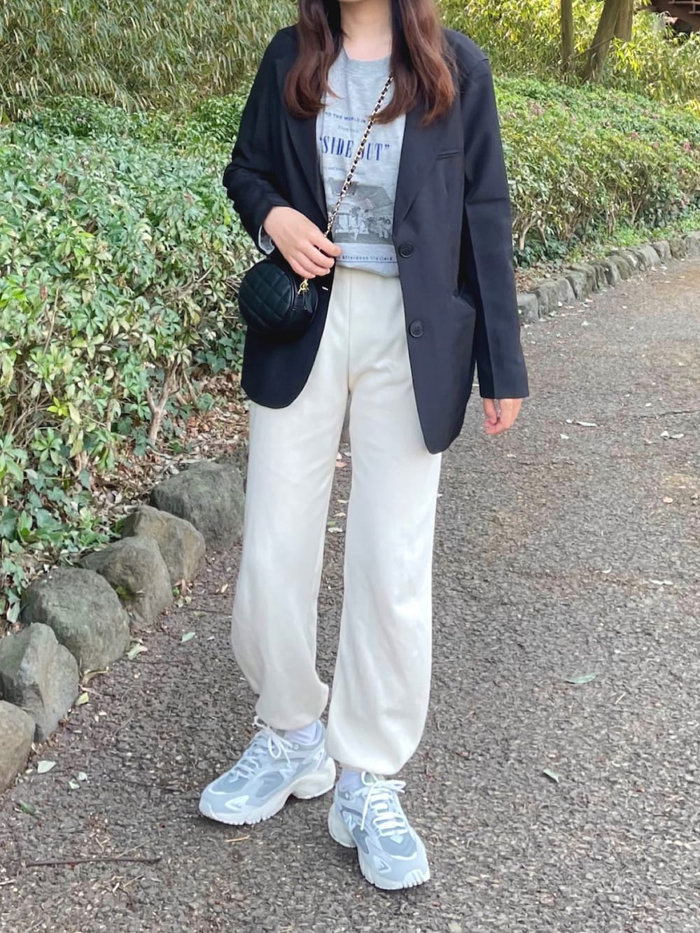 ブラック系のテーラードジャケット、グレー系のTシャツ/カットソー、ブラック系のショルダーバッグを着用したレディースの春コーディネートの2枚目の写真