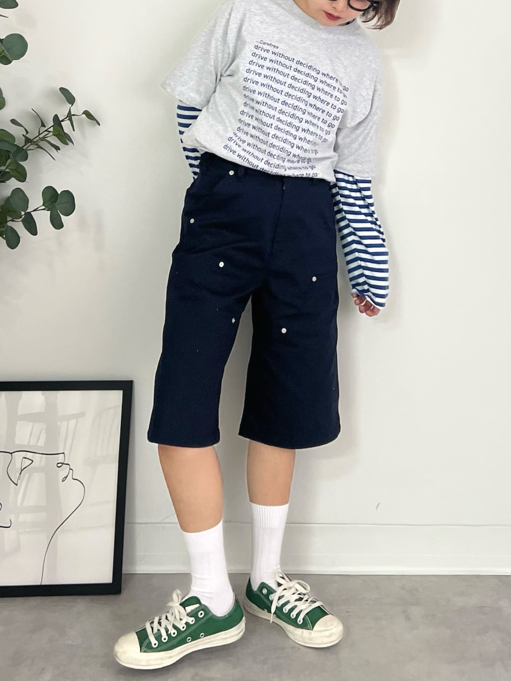 グレー系のTシャツ/カットソー、ブルー系のチノパンツ、グリーン系のスニーカーを着用したレディースの秋コーディネートの3枚目の写真