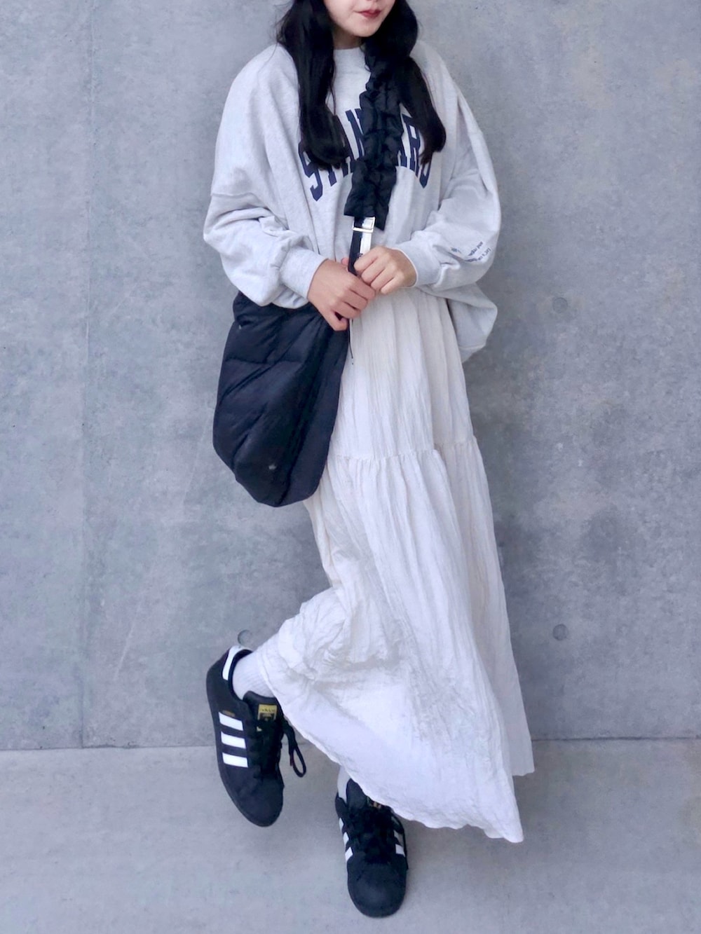 ホワイト系のスウェット、ホワイト系のスカート、ブラック系のスニーカーを着用したレディースの秋コーディネートの3枚目の写真