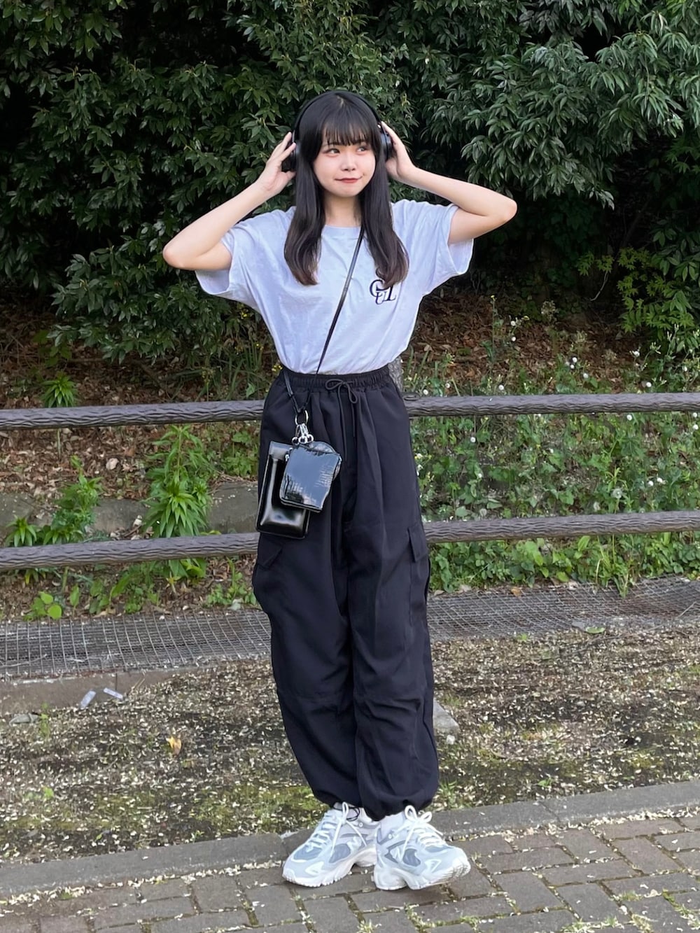 ブラック系のカーゴパンツ、ブラック系のショルダーバッグ、ホワイト系のTシャツ/カットソーを着用したレディースの春コーディネートの4枚目の写真