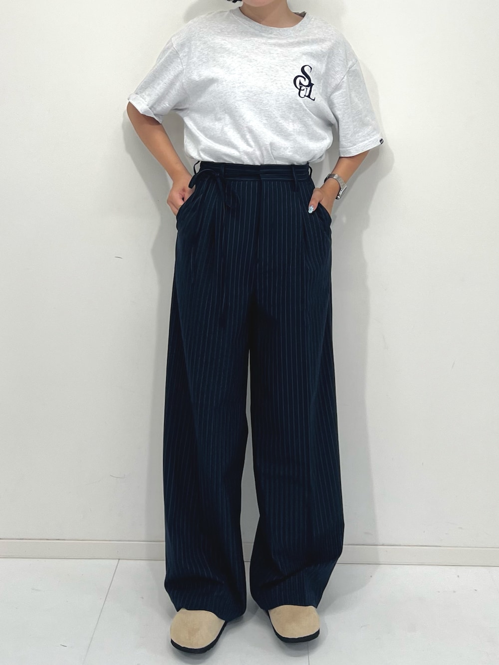 ブルー系のスラックス、ベージュ系のサンダル、ホワイト系のTシャツ/カットソーを着用したレディースの夏コーディネートの5枚目の写真