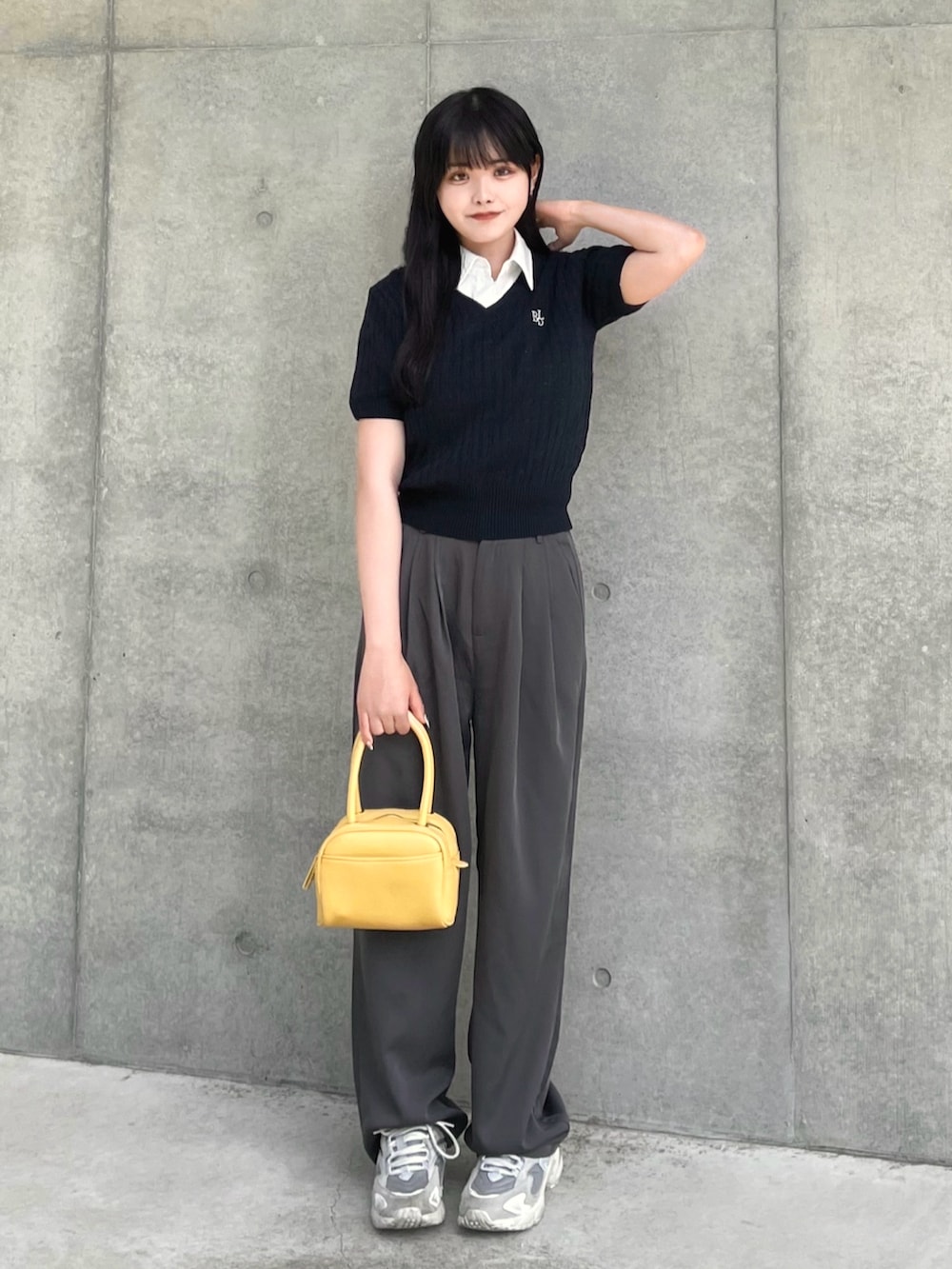 ブルー系のニット/セーター、ホワイト系のシャツ/ブラウス、グレー系のスラックスを着用したレディースの夏コーディネートの2枚目の写真