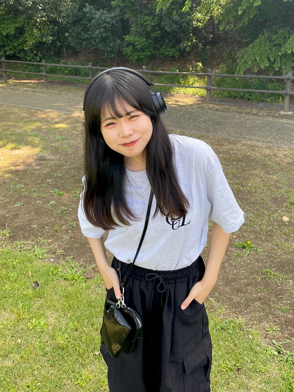 ブラック系のカーゴパンツ、ブラック系のショルダーバッグ、ホワイト系のTシャツ/カットソーを着用したレディースの春コーディネートの3枚目の写真