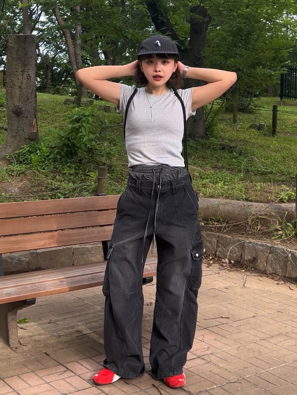 グレー系のTシャツ/カットソー、ブラック系のデニムパンツ、レッド系のスニーカーを着用したレディースの夏コーディネートの2枚目の写真