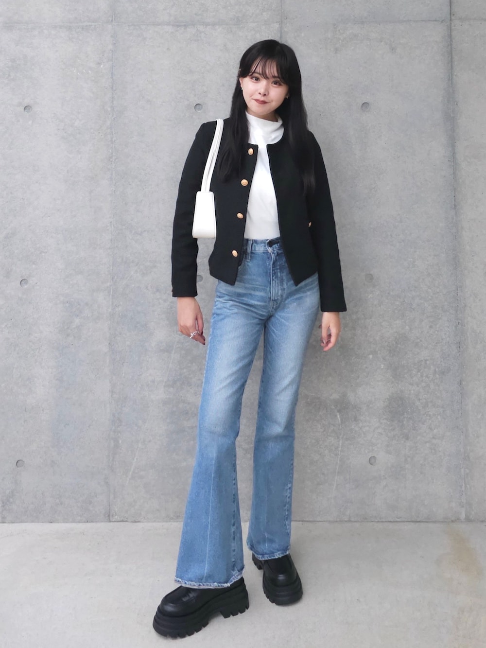 ブラック系のブーツ、ブラック系のノーカラージャケット、ホワイト系のTシャツ/カットソーを着用したレディースの秋コーディネートの2枚目の写真