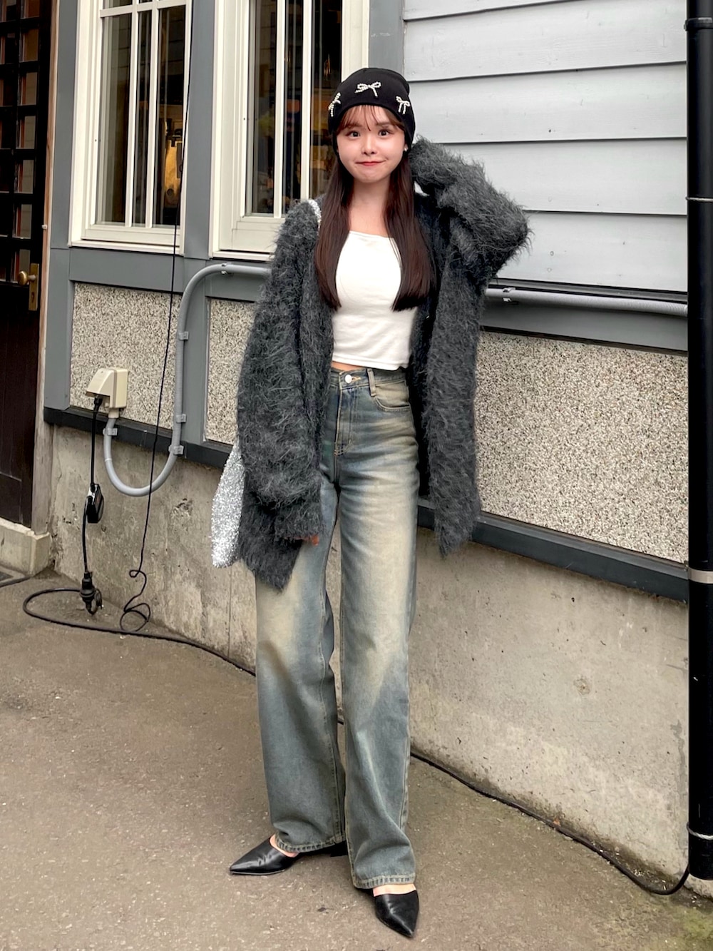 ブラック系のカーディガン/ボレロ、ブルー系のデニムパンツ、ホワイト系のキャミソールを着用したレディースの秋コーディネートの2枚目の写真