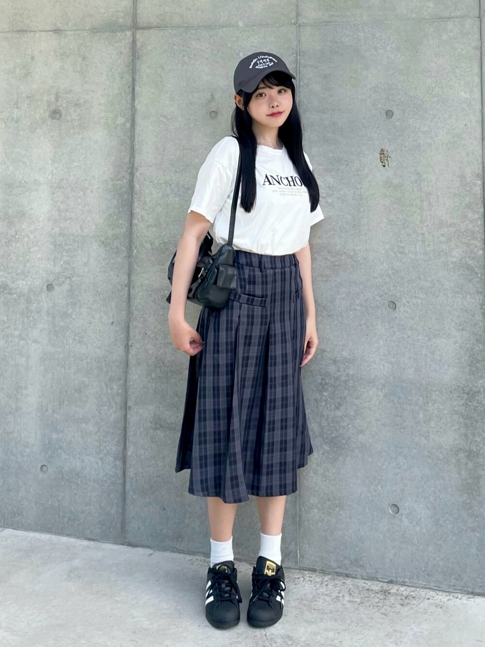 ホワイト系のTシャツ/カットソー、ブラック系のスカート、ブラック系のショルダーバッグを着用したレディースの夏コーディネートの2枚目の写真