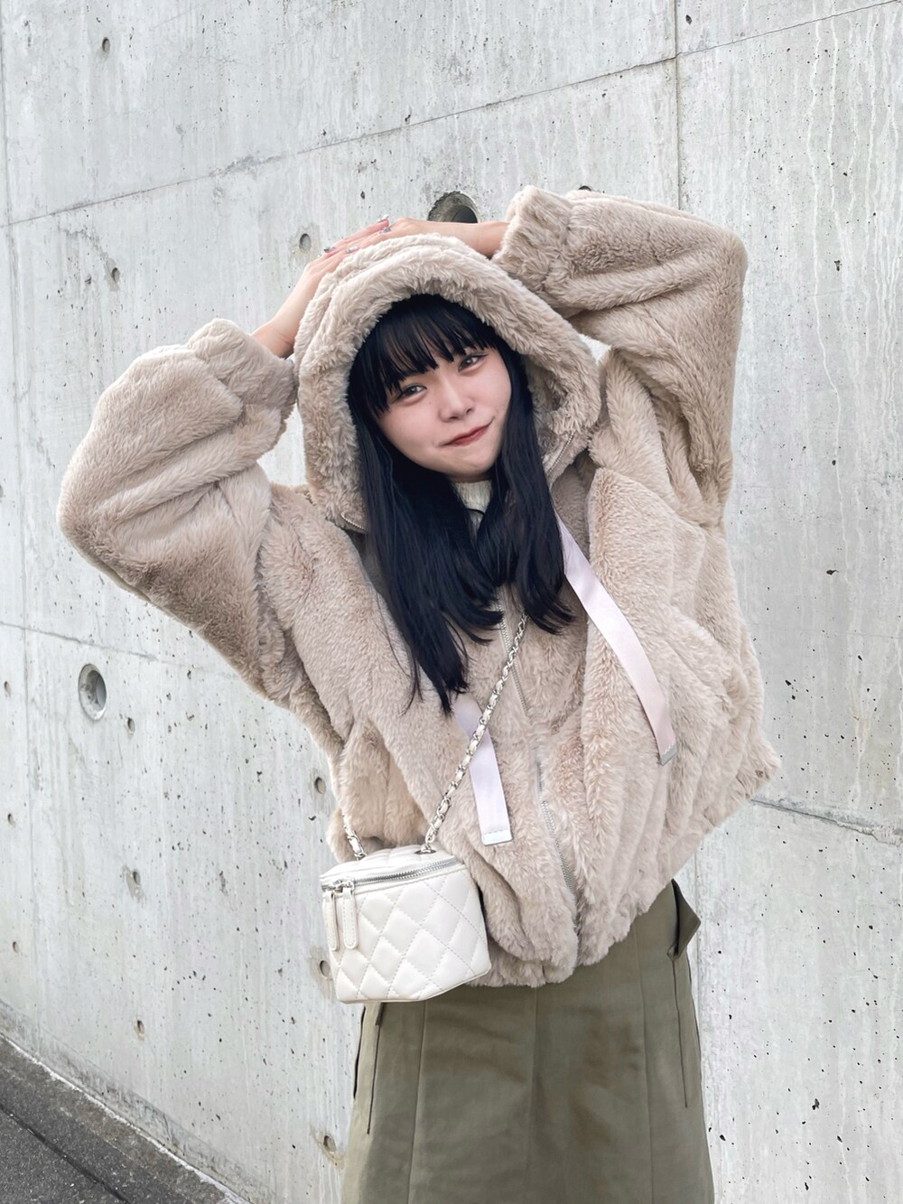 ベージュ系のブルゾン、ホワイト系のショルダーバッグ、グリーン系のスカートを着用したレディースの秋コーディネートの2枚目の写真