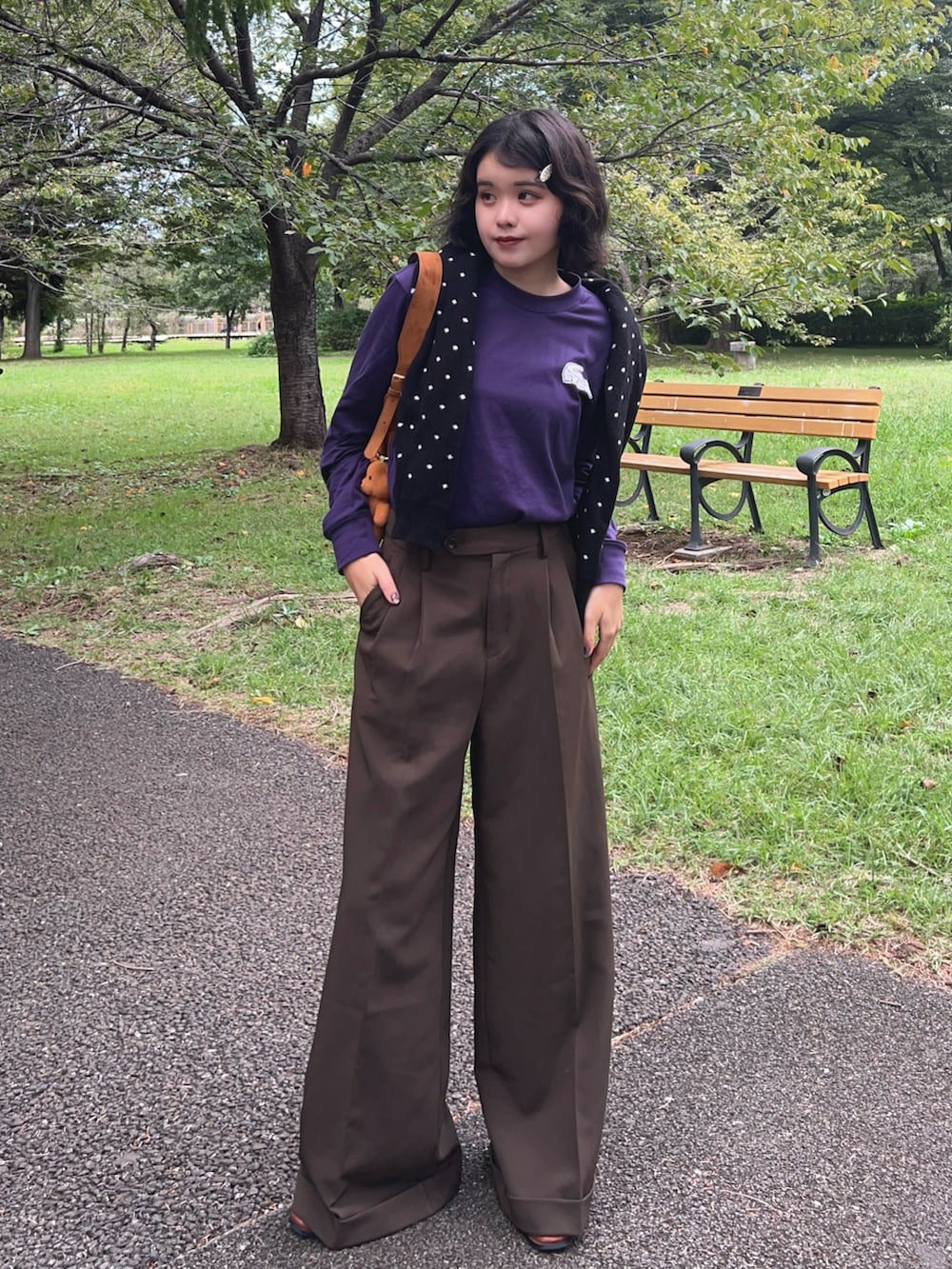 イエロー系のトートバッグ、パープル系のTシャツ/カットソー、ブラック系のカーディガン/ボレロを着用したレディースの秋コーディネートの2枚目の写真