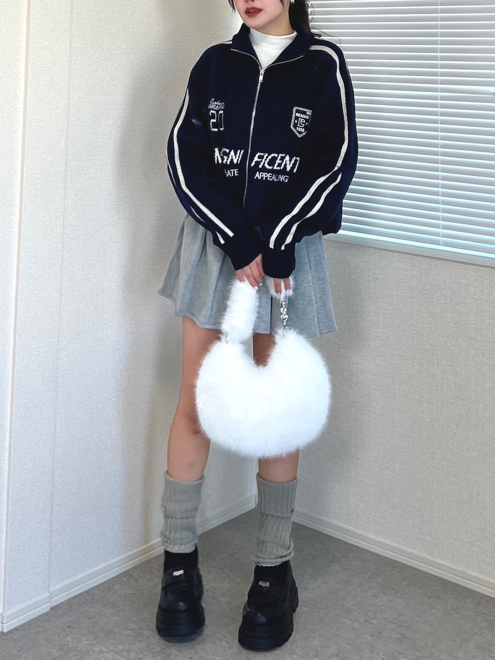 ブルー系のカーディガン/ボレロ、ホワイト系のTシャツ/カットソー、グレー系のスカートを着用したレディースの冬コーディネートの3枚目の写真