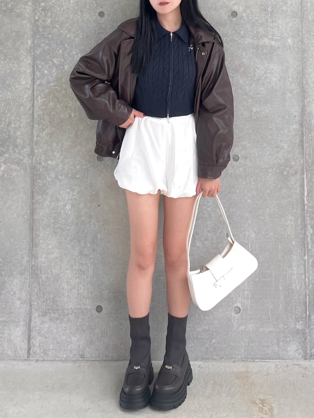 ブラウン系のブーツ、ブラウン系のライダースジャケット、ブルー系のニット/セーターを着用したレディースの秋コーディネートの3枚目の写真