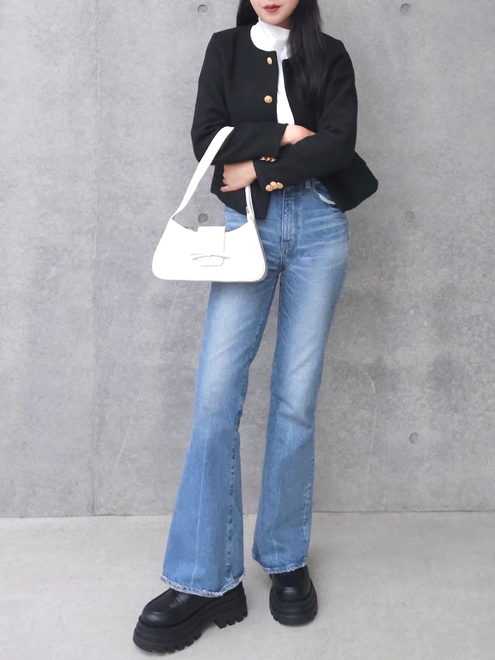 ブラック系のブーツ、ブラック系のノーカラージャケット、ホワイト系のTシャツ/カットソーを着用したレディースの秋コーディネートの3枚目の写真