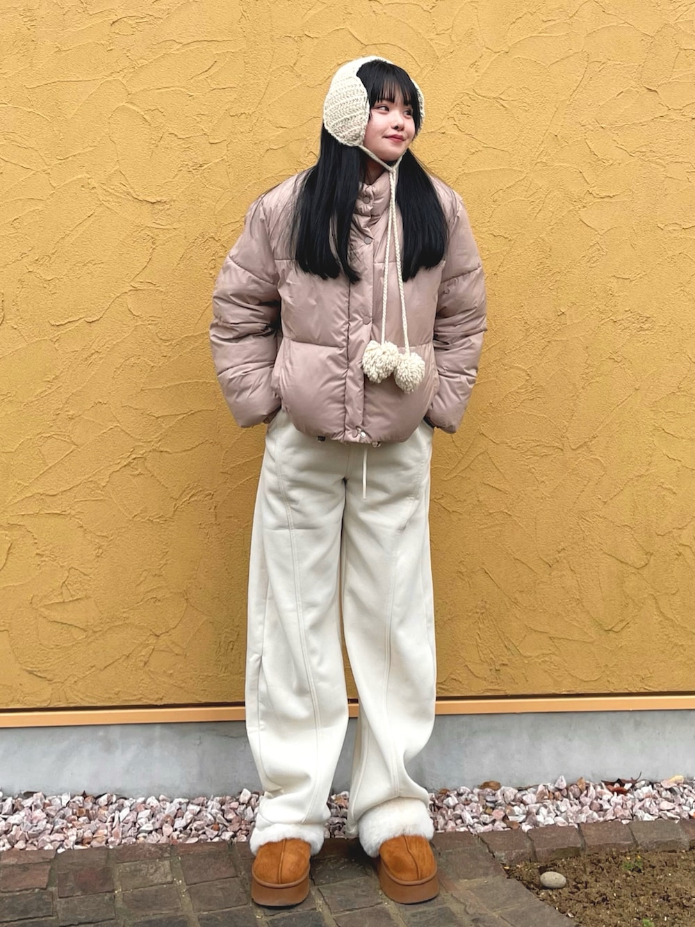 ベージュ系のダウンジャケット/コート、ベージュ系のスウェットパンツ、イエロー系のスリッポンを着用したレディースの冬コーディネートの2枚目の写真