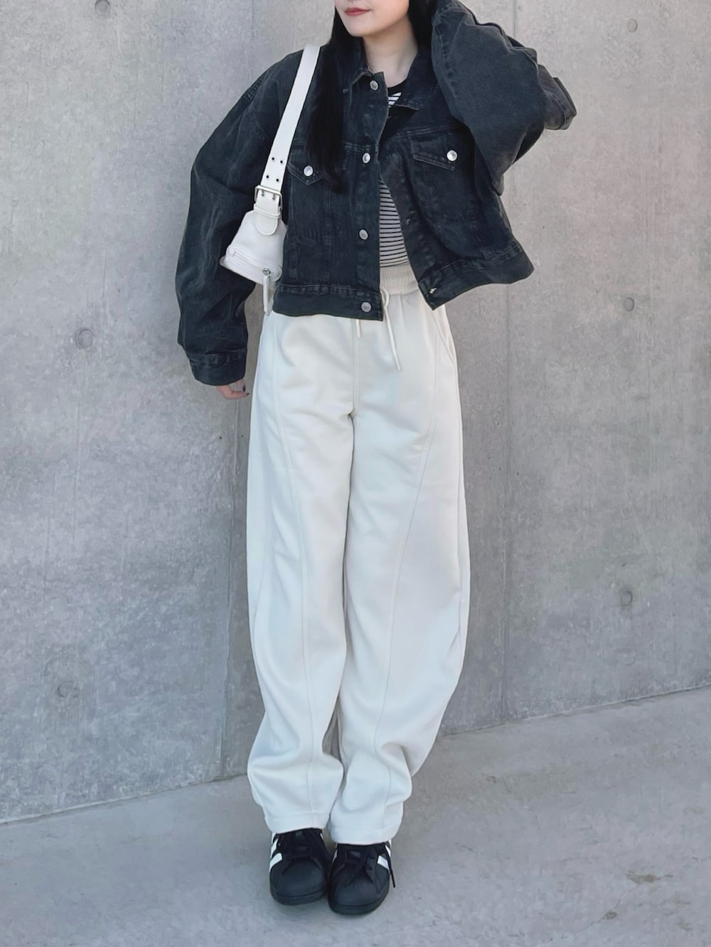 ブラック系のデニムジャケット、ブラック系のTシャツ/カットソー、ホワイト系のショルダーバッグを着用したレディースの春コーディネートの3枚目の写真