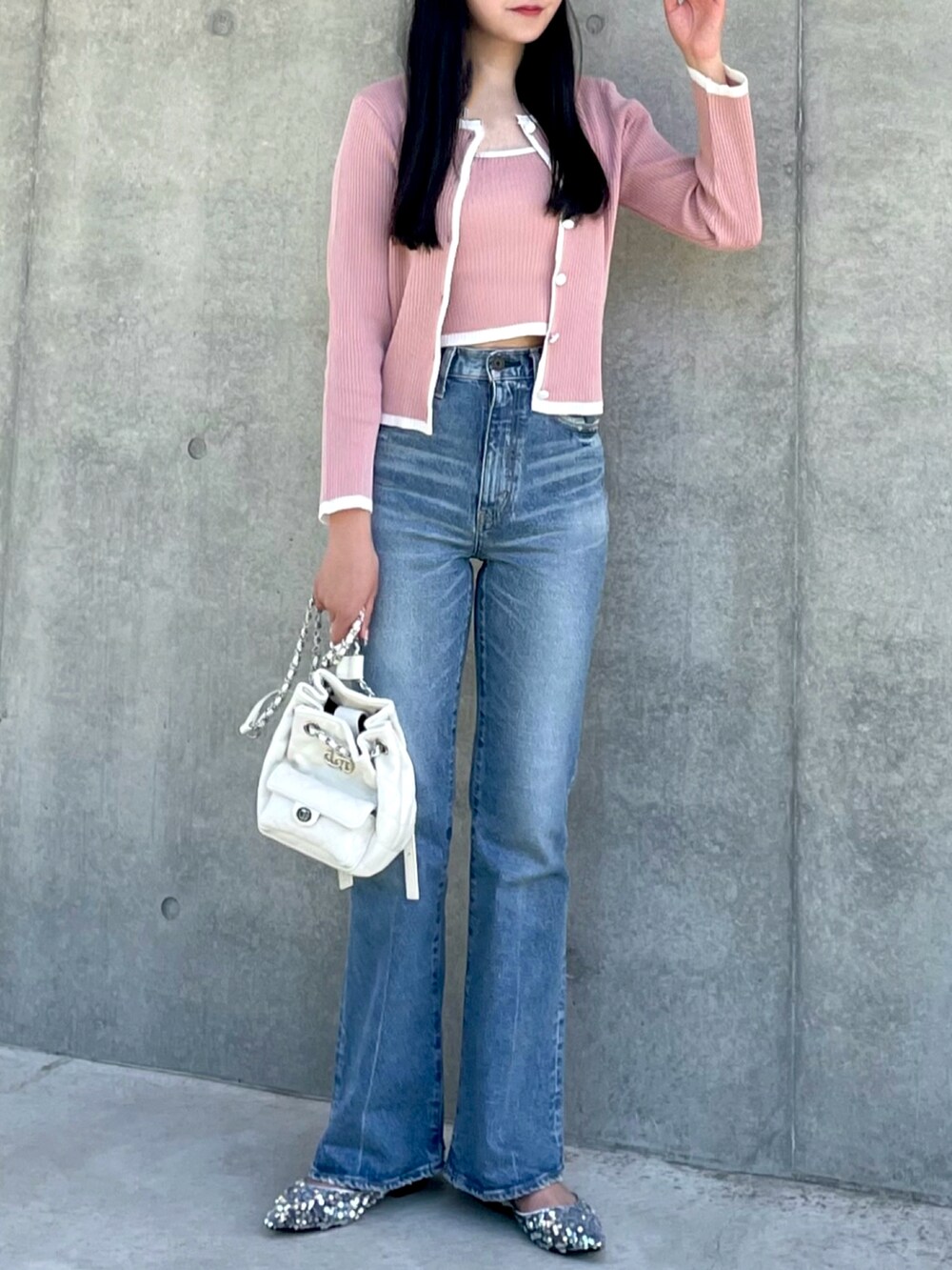 ピンク系のカーディガン/ボレロ、ブルー系のデニムパンツ、ホワイト系のバックパック/リュックを着用したレディースの春コーディネートの3枚目の写真