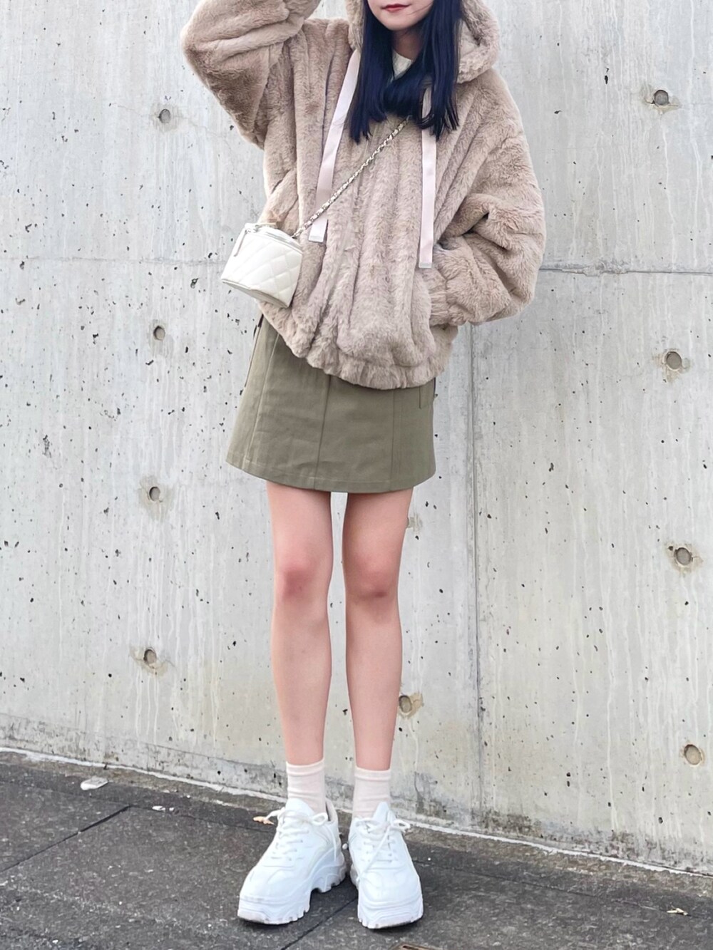 ベージュ系のブルゾン、ホワイト系のショルダーバッグ、グリーン系のスカートを着用したレディースの秋コーディネートの4枚目の写真