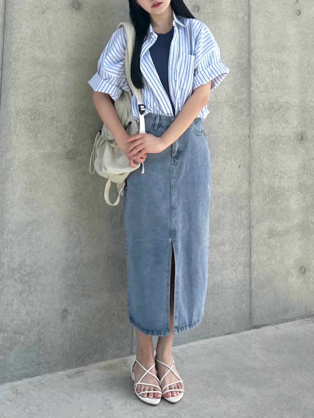 ホワイト系のシャツ/ブラウス、ブルー系のデニムスカート、ベージュ系のバックパック/リュックを着用したレディースの春コーディネートの3枚目の写真