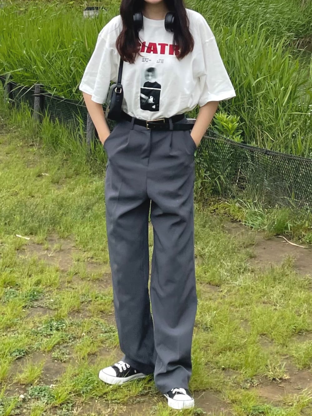 ホワイト系のTシャツ/カットソー、グレー系のスラックス、ブラック系のバッグを着用したレディースの春コーディネートの3枚目の写真