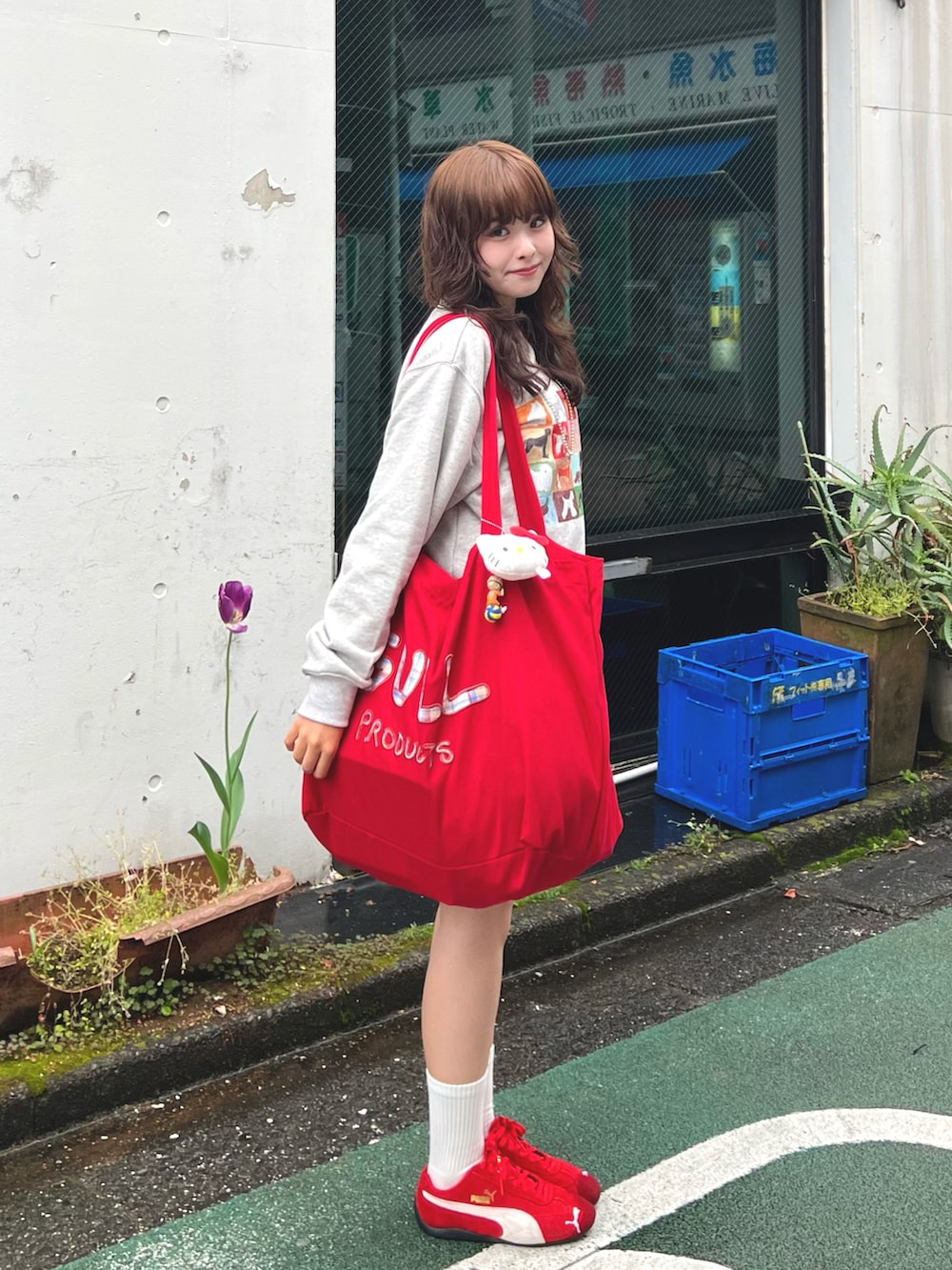 レッド系のバッグ、ホワイト系のスウェット、ブルー系のデニムスカートを着用したレディースの春コーディネートの2枚目の写真