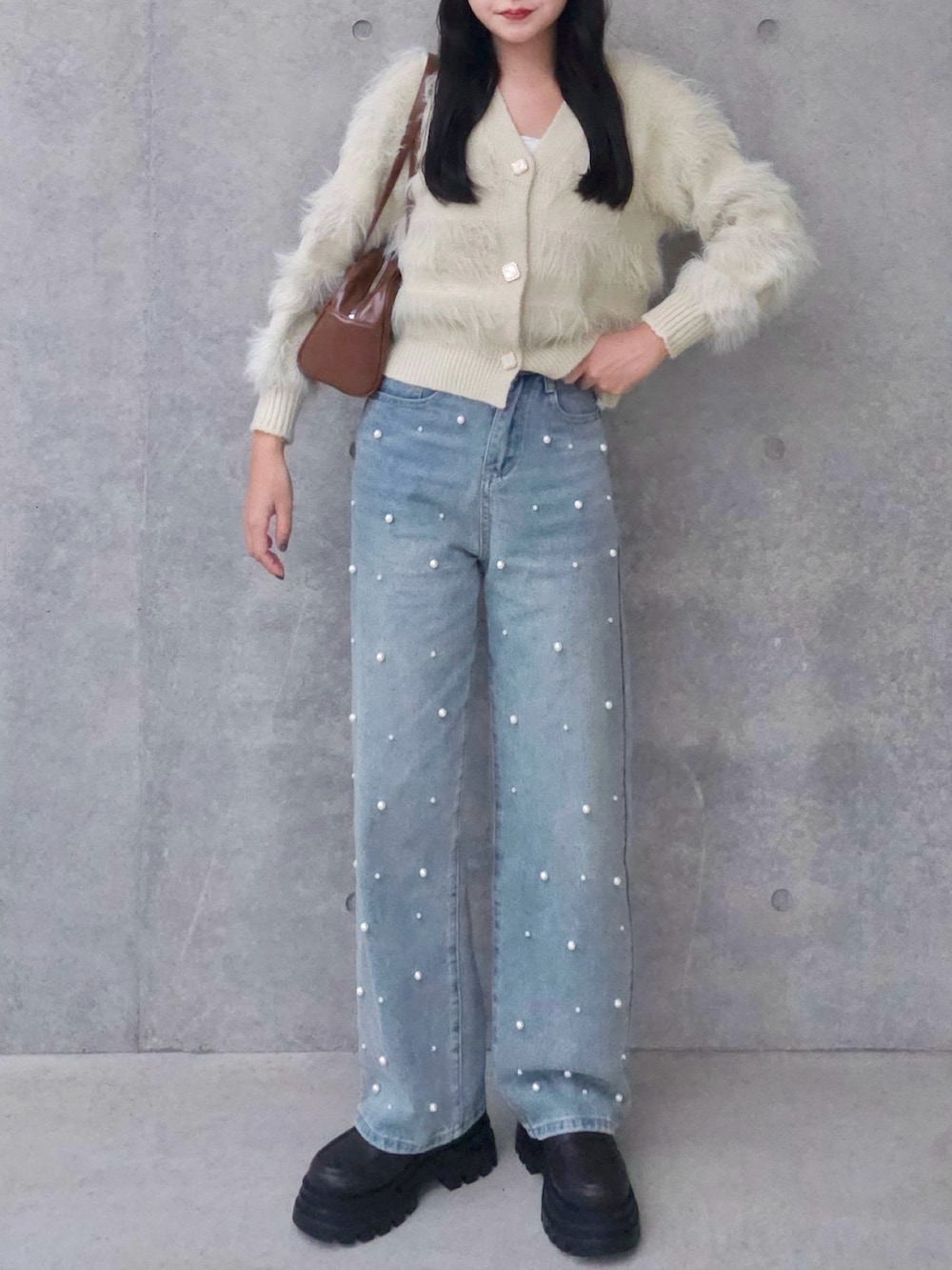 ベージュ系のカーディガン/ボレロ、ブルー系のデニムパンツ、ブラウン系のボストンバッグを着用したレディースの秋コーディネートの3枚目の写真