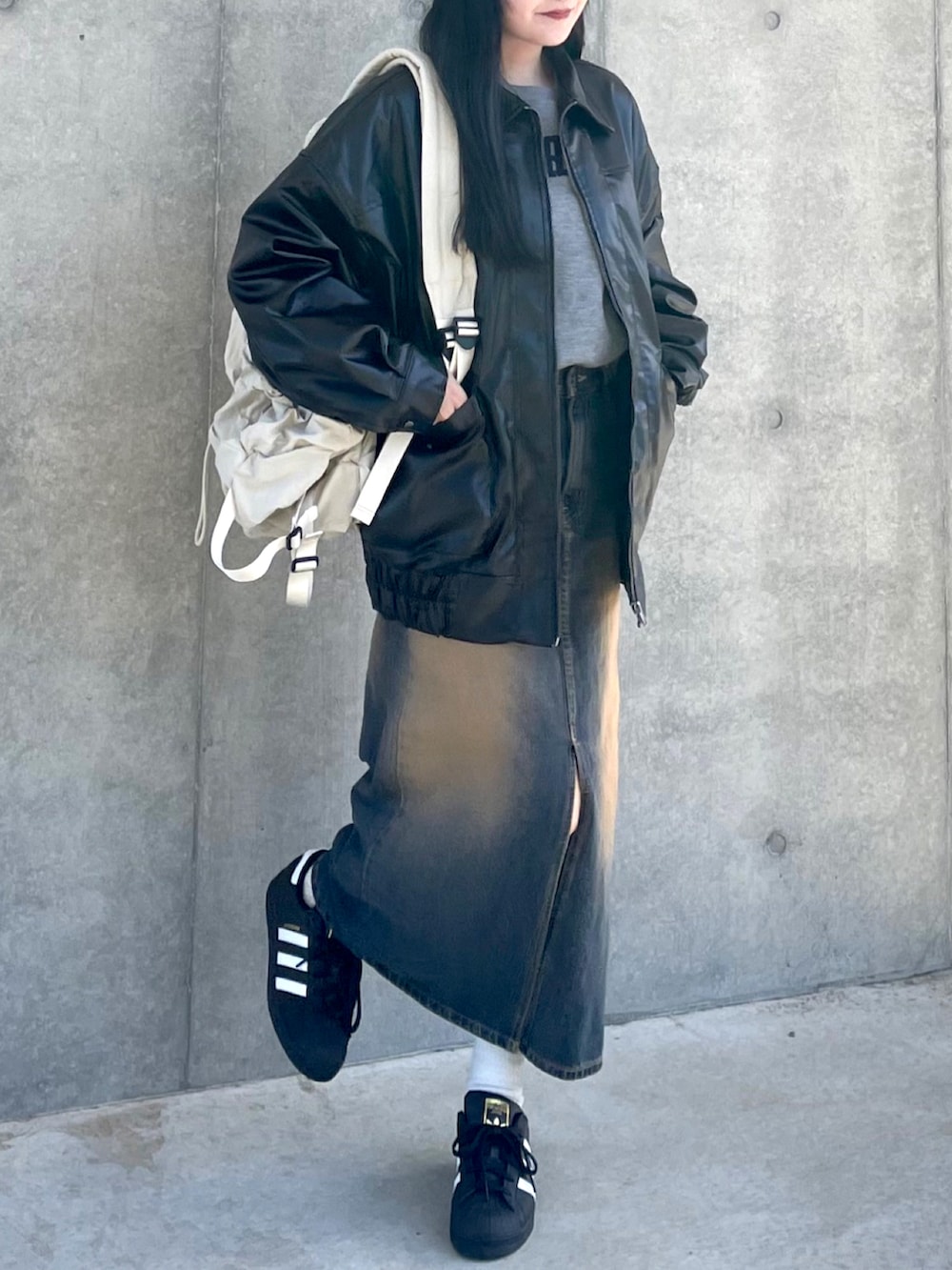 ブラック系のブルゾン、グレー系のスウェット、ブルー系のデニムスカートを着用したレディースの春コーディネートの3枚目の写真