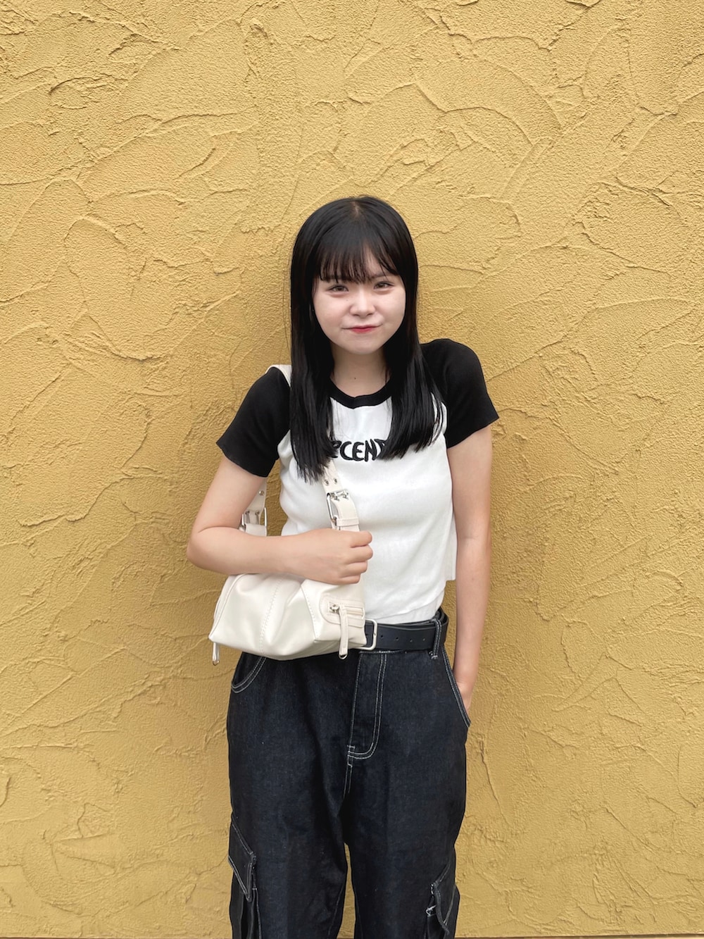 ホワイト系のTシャツ/カットソー、ブラック系のカーゴパンツ、ホワイト系のショルダーバッグを着用したレディースの夏コーディネートの2枚目の写真