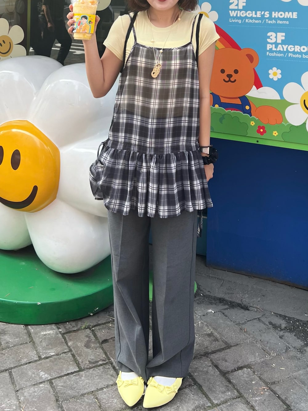 イエロー系のTシャツ/カットソー、ブラック系のバックパック/リュック、イエロー系のパンプスを着用したレディースの夏コーディネートの3枚目の写真