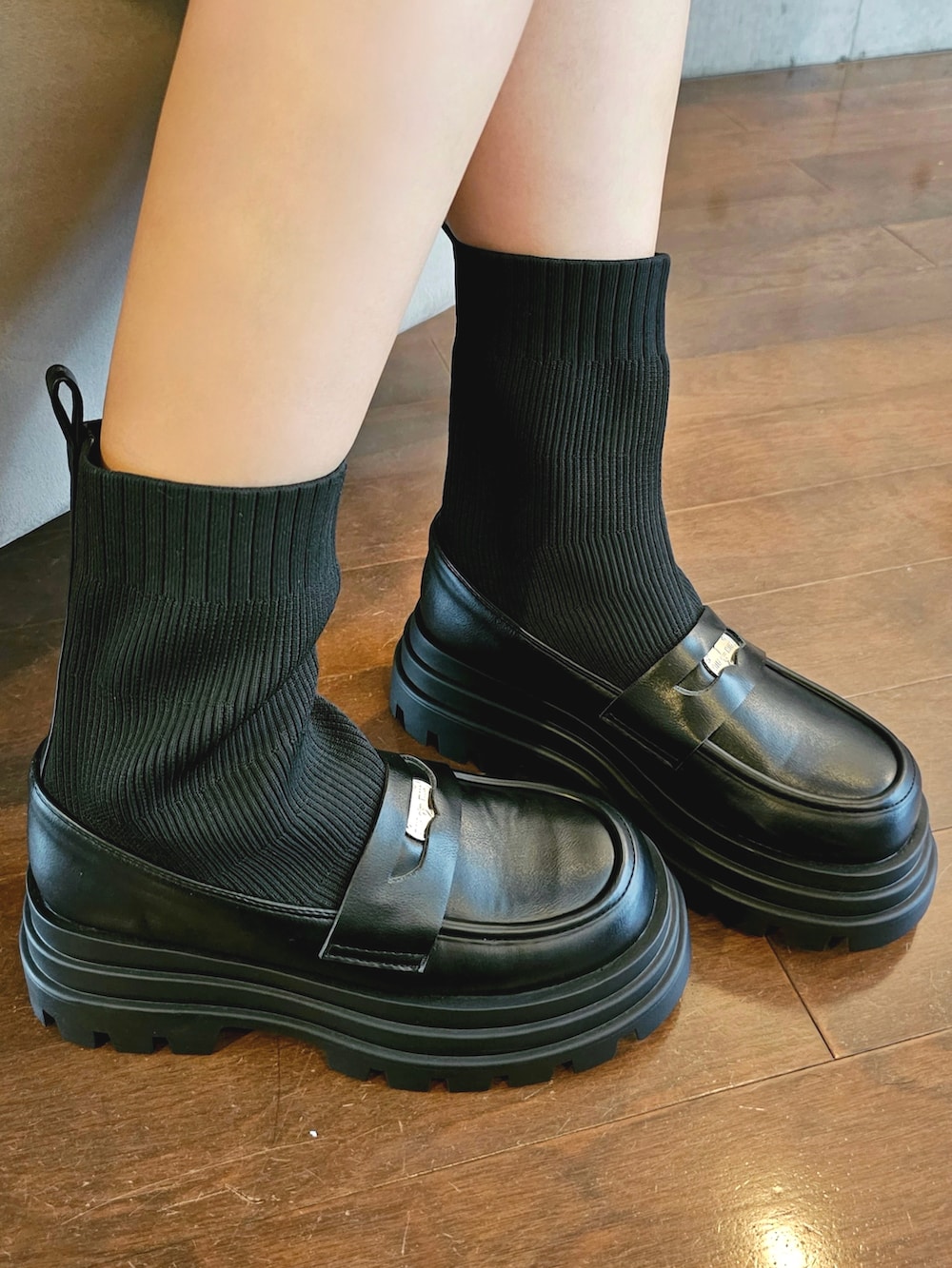 ブラック系のスウェット、ホワイト系のスカート、ブラック系のショルダーバッグを着用したレディースの秋コーディネートの3枚目の写真