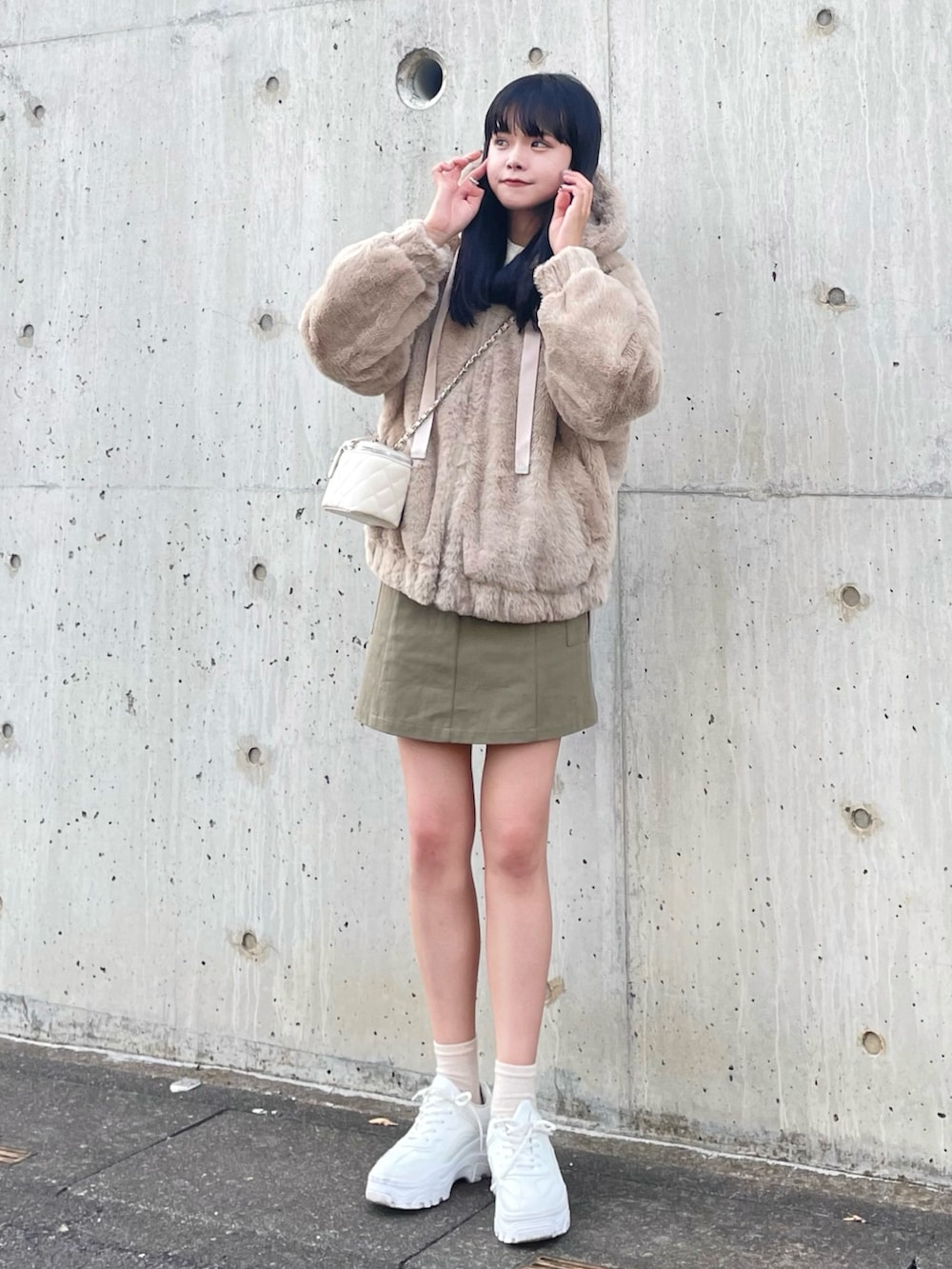 ベージュ系のブルゾン、ホワイト系のショルダーバッグ、グリーン系のスカートを着用したレディースの秋コーディネートの3枚目の写真
