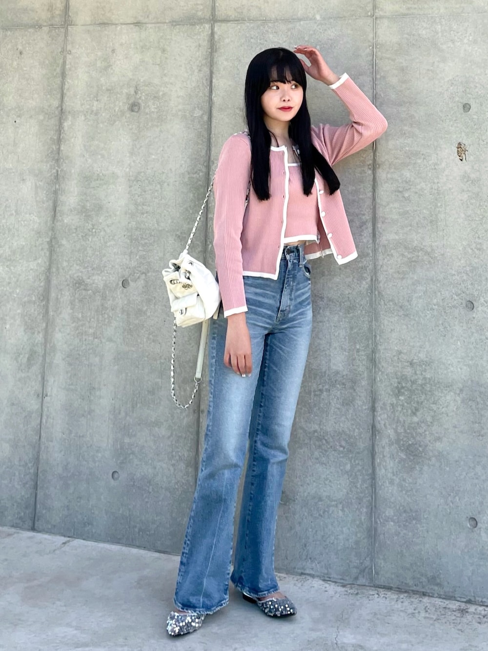 ピンク系のカーディガン/ボレロ、ブルー系のデニムパンツ、ホワイト系のバックパック/リュックを着用したレディースの春コーディネートの2枚目の写真