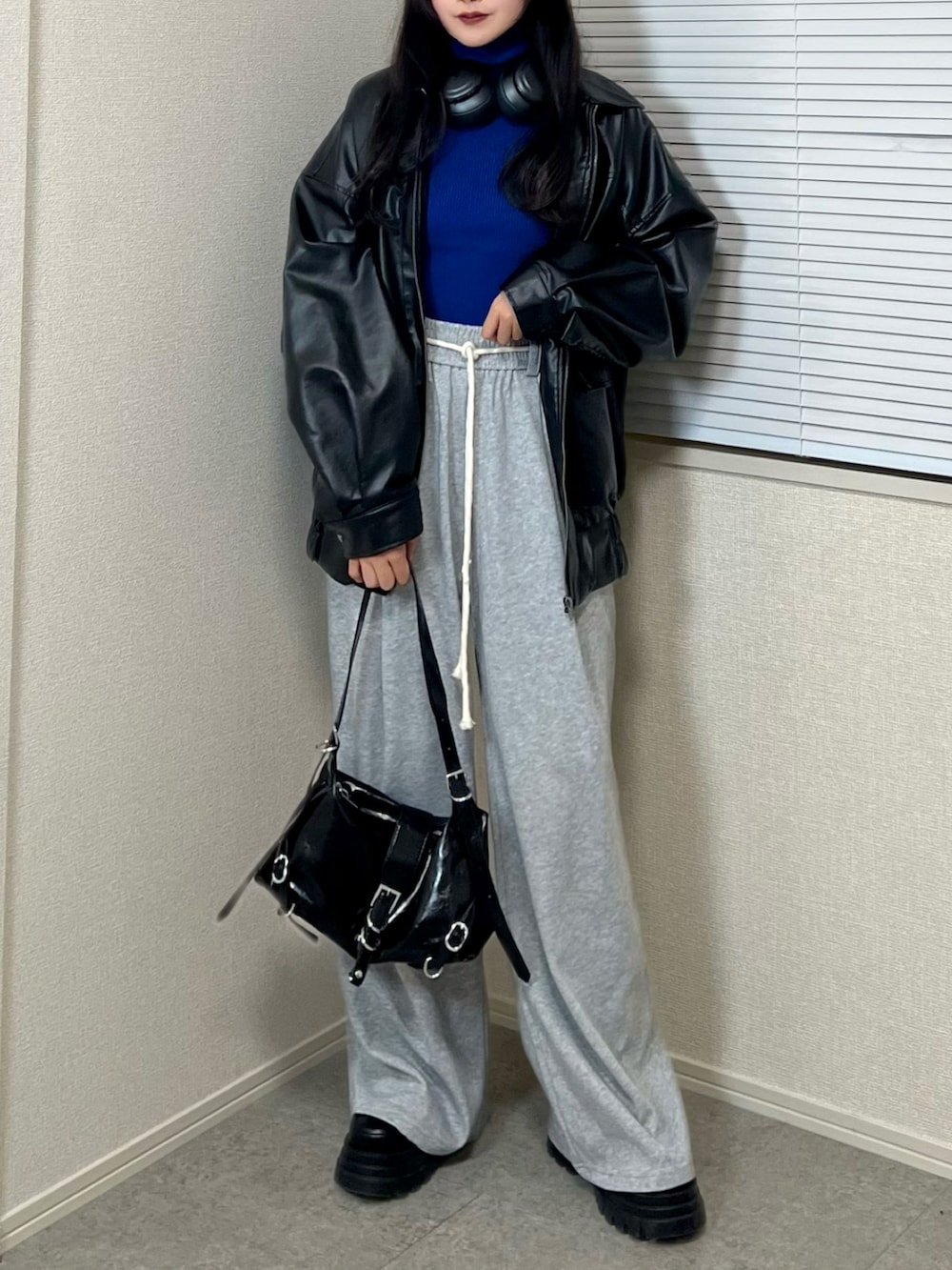 ブルー系のニット/セーター、ブラック系のブルゾン、グレー系のその他パンツを着用したレディースの冬コーディネートの3枚目の写真
