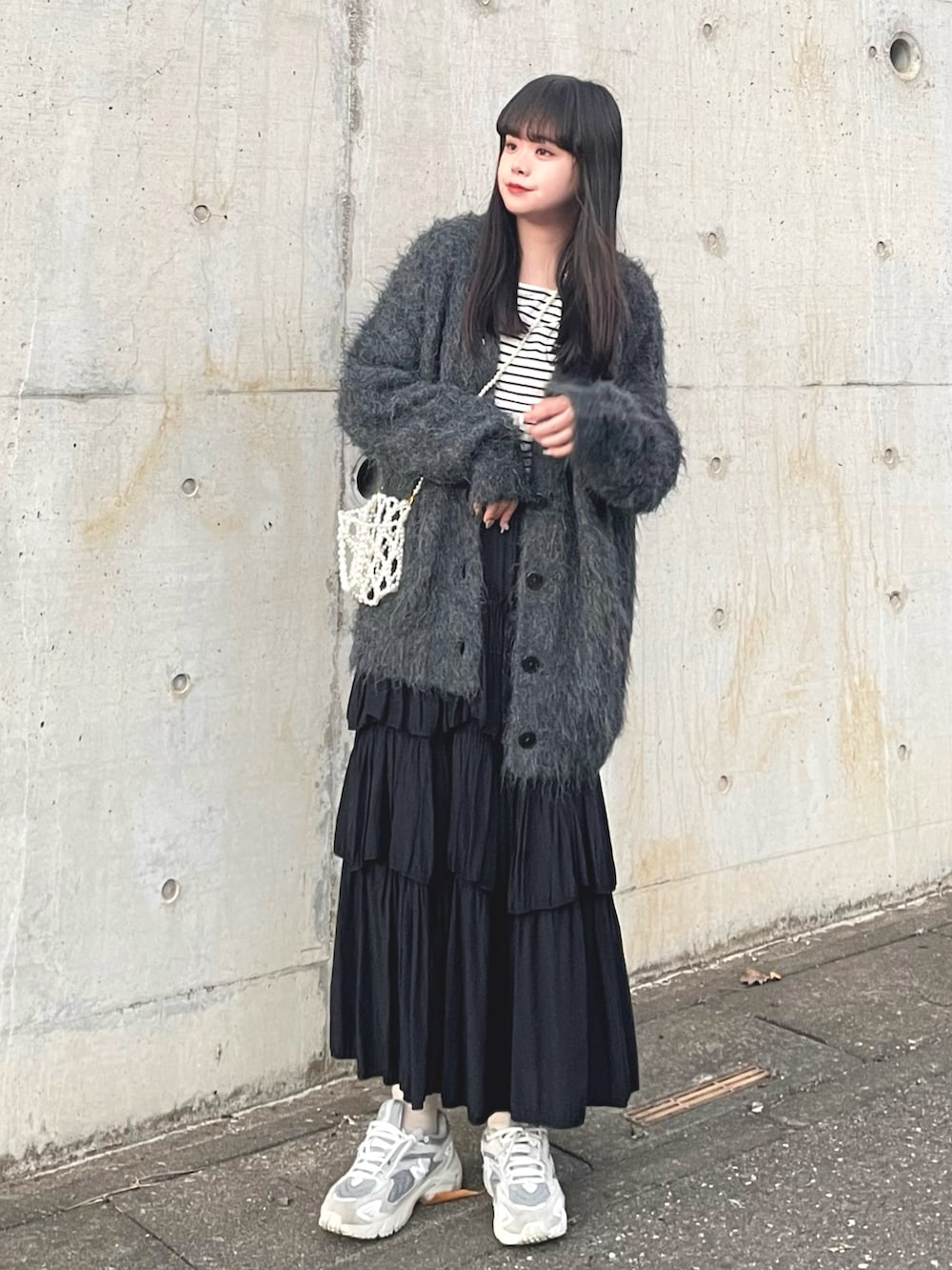 ブラック系のカーディガン/ボレロ、ブルー系のTシャツ/カットソー、ブラック系のスカートを着用したレディースの秋コーディネートの2枚目の写真
