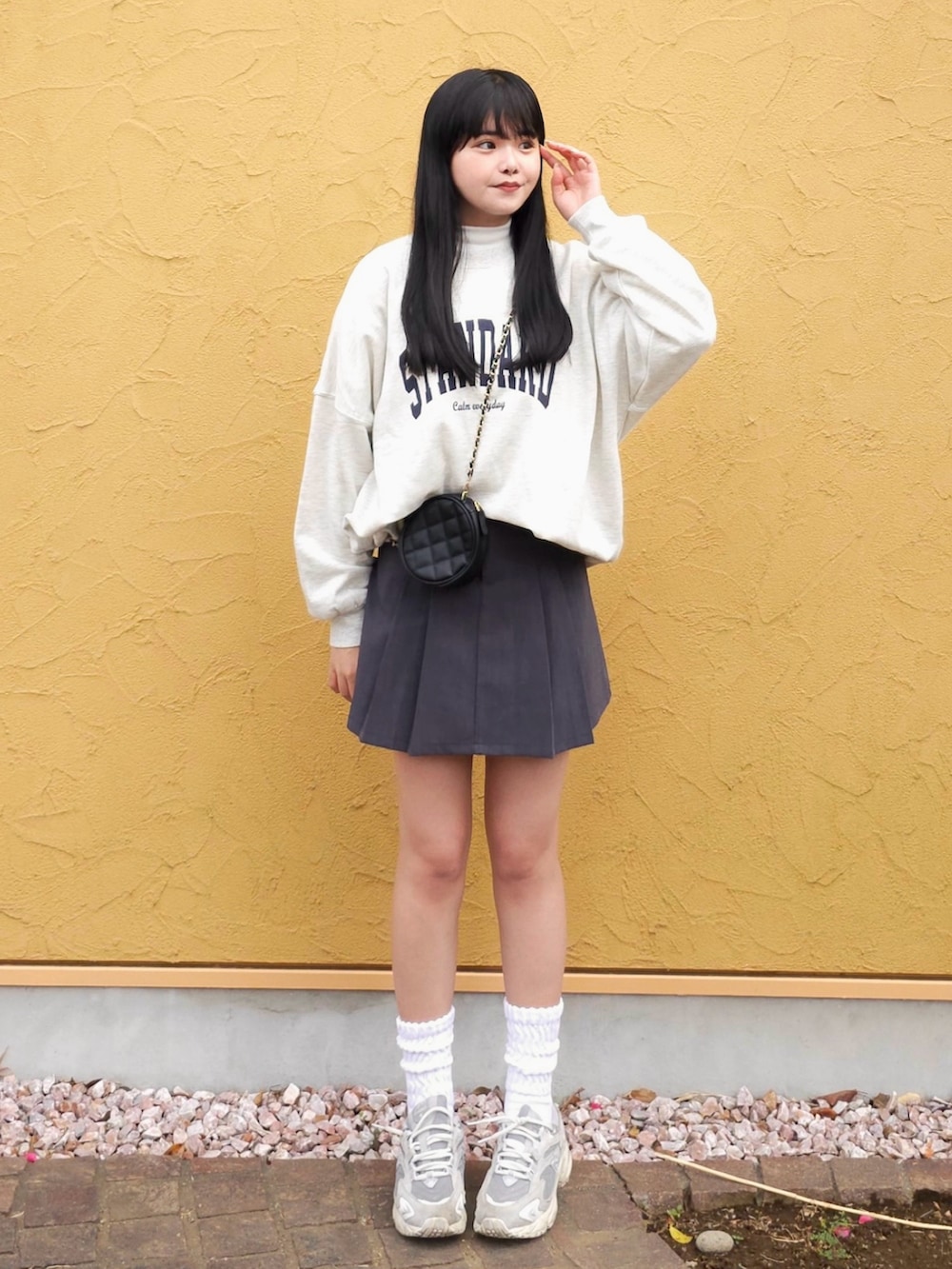 ホワイト系のスウェット、ホワイト系のTシャツ/カットソー、グレー系のスカートを着用したレディースの冬コーディネートの2枚目の写真