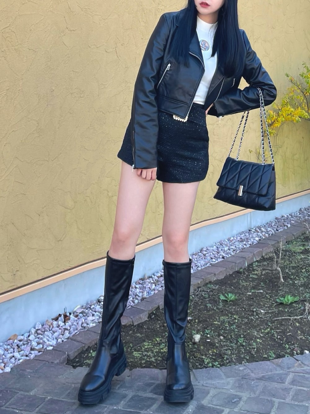 ブラック系のライダースジャケット、ホワイト系のニット/セーター、ブラック系のその他パンツを着用したレディースの冬コーディネートの3枚目の写真