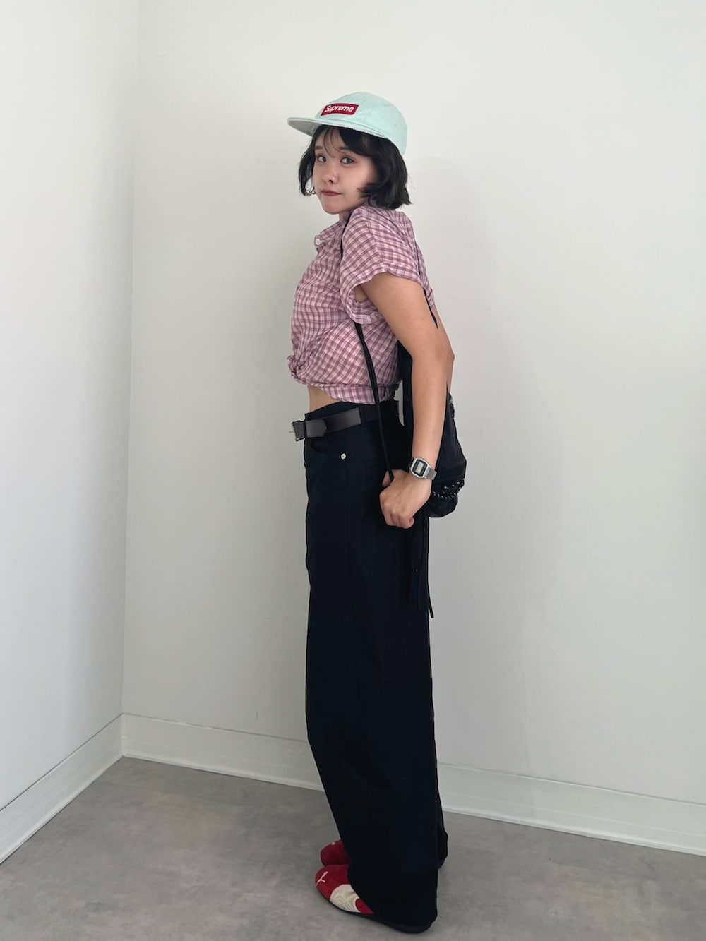 ブラック系のチノパンツ、ピンク系のシャツ/ブラウス、レッド系のスニーカーを着用したレディースの夏コーディネートの2枚目の写真