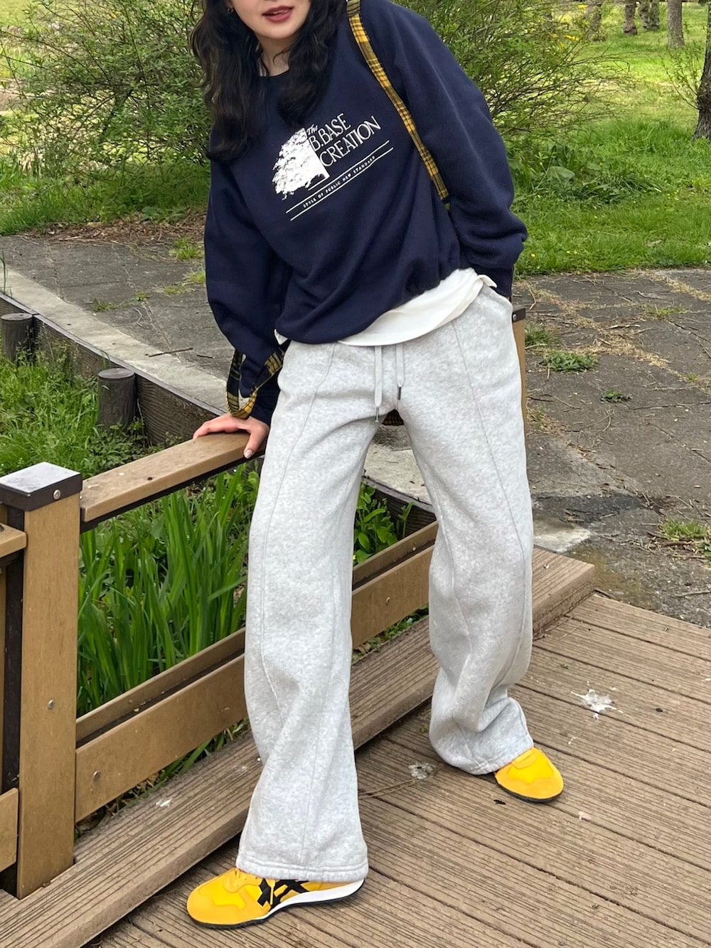 ブルー系のスウェット、グレー系のスウェットパンツ、イエロー系のスニーカーを着用したレディースの春コーディネートの3枚目の写真